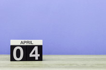 April 4th. Day 4 Of Month, Calendar On Wooden Table And Purple Background. Spring Time, Empty Space For Text