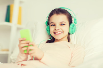 Poster - happy girl lying in bed with smartphone at home