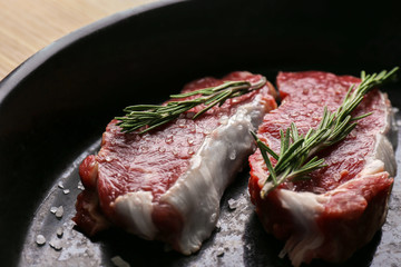 Canvas Print - Raw steaks with rosemary and salt, closeup