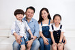 Leinwandbild Motiv Happy Asian Chinese family sitting on the couch smiling