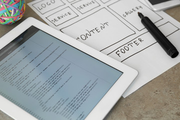 Tablet with programming code for website on table
