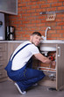 © Africa Studio - Plumber repairing sink pipes in kitchen