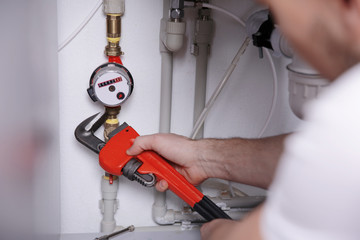 Wall Mural - Plumber repairing sink pipes in kitchen, closeup