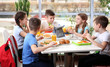 © Africa Studio - Children sitting at cafeteria table while eating lunch