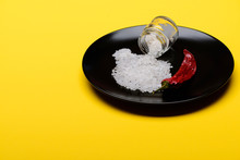 Glass Jar With Salt And Red Pepper On Black Plate