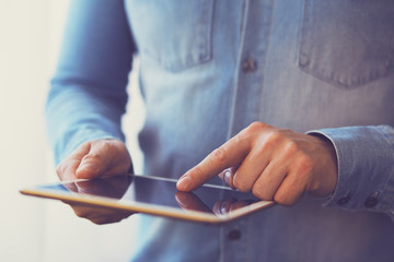 Wall Mural - man holding white digital tablet, view close up. toned