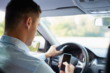 Wall Mural - man in the car holding black mobile phone