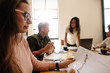 © Jacob Lund - Woman looking at document during meeting in conference room