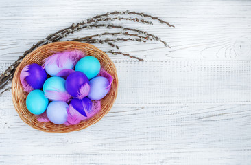 Wall Mural - Basket with colored eggs on a white background. Concept Happy Easter.