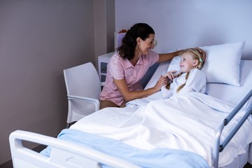 Canvas Print - Female doctor consoling patient during visit in ward