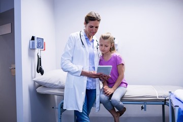 Canvas Print - Doctor showing medical report in digital tablet to patient