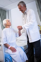 Canvas Print - Doctor consoling senior patient in ward