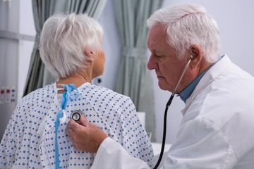 Sticker - Doctor examining senior patient with stethoscope