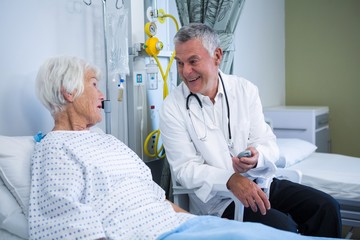 Canvas Print - Doctor interacting with senior patient in ward