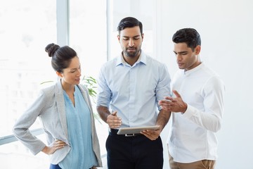 Wall Mural - Business colleagues discussing over digital tablet in office