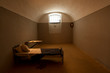 Dark prison cell with antique furniture inside historical fortress
