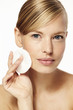 © sanneberg - Beautiful woman cleansing skin with cotton pad, portrait