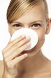 © sanneberg - Woman holding cotton pad in front of face, portrait