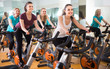 © caftor - several women of different age training on exercise bikes