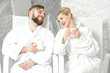 Couple drinking mineral water sitting in the salt room. Applying salt therapy in the Spa