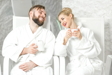 Couple drinking mineral water sitting in the salt room. Applying salt therapy in the Spa