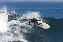 A Surfer Carves Fast Through A Blue Wave.