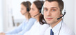 © rogerphoto - Call center operators. Focus at businessman in headset while consulting customers.