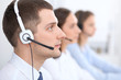 © rogerphoto - Call center operators. Focus at businessman in headset while consulting customers.
