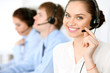 © rogerphoto - Call center operators. Focus at brunette business woman in headset