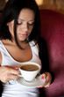 © Raisa Kanareva - young woman sitting in a cafe drinking coffee