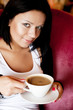 © Raisa Kanareva - young woman sitting in a cafe drinking coffee