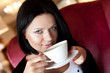 © Raisa Kanareva - young woman sitting in a cafe drinking coffee