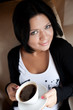 © Raisa Kanareva - young woman sitting in a cafe drinking coffee