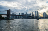 Fototapeta  - Manhattan Downtown Financial District Skyline and Brooklyn Bridge as Seen from Mainstreet Park in Brooklyn at Sunset, USA