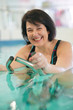 Overweight woman in spa center doing aquabike exercises