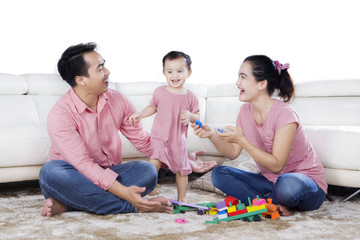 Wall Mural - Cheerful family plays with toys on studio