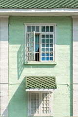 Wall Mural - Antique white frame wooden window with beautiful light and shadow the old green brick wall retro style