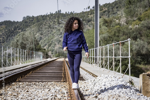 Fotografia, Obraz Niña jugando feliz en las vías del tren.
