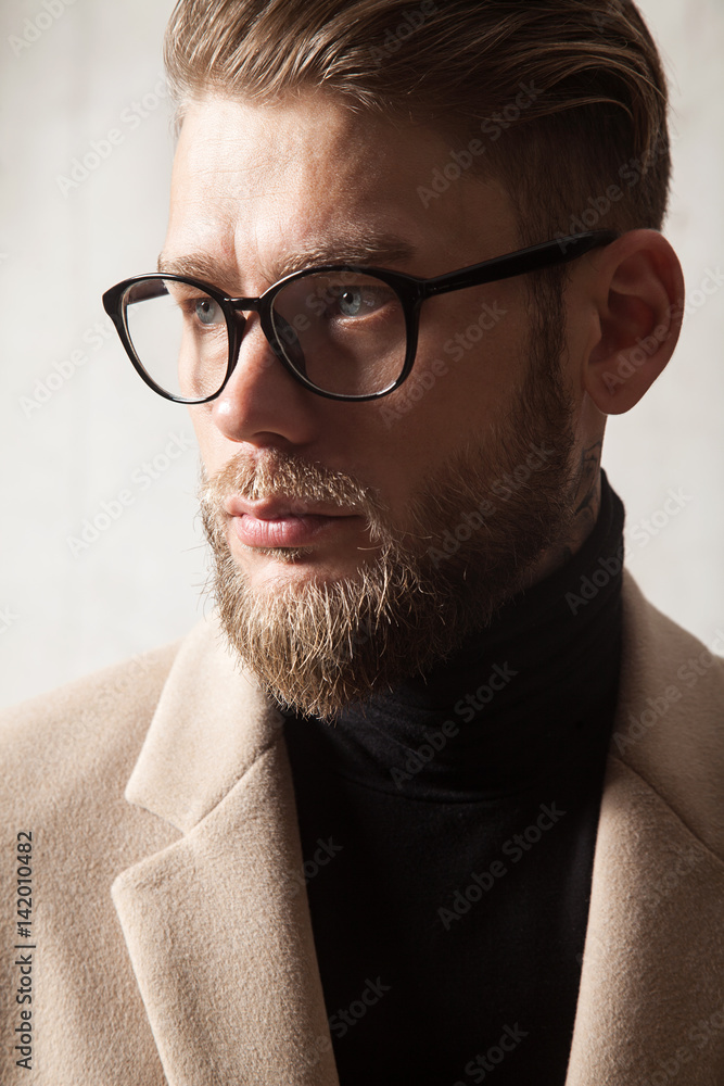 Portrait of a handsome stylish man wearing glasses and a beige coat Stock Photo Adobe Stock