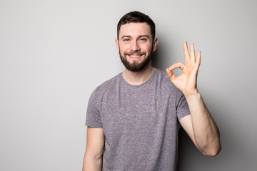 Portrait of a cheerful young man showing okay gesture