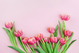 Pink tulip flowers on pastel background top view in flat lay style. Greeting card for Woman or Mother Day.
