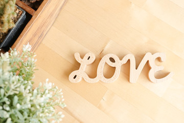 LOVE alphabets of wooden letters isolated on the light wood background, top view. Love and Valentine's day concept