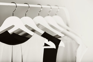 Black-and-white photo with the blur. Women's clothing on a white hanger.