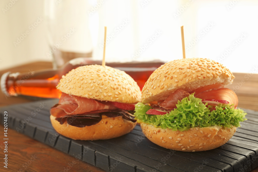 Tasty burgers on wooden board