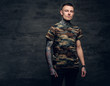 © Fxquadro - A man with tattoos on his neck, face and arms, dressed in a camouflage t shirt.