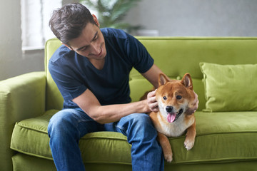 hipster man snuggling and hugging his dog, close friendship loving bond between owner and pet husky