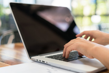 Closeup of business woman hand typing on laptop keyboard .