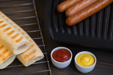 Wall Mural - Barbecue Grilled Hot Dog with Yellow Mustard and ketchup on wooden table