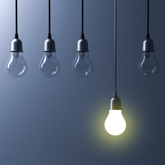 One hanging light bulb glowing different and standing out from unlit incandescent bulbs with reflection on dark cyan background , leadership and different business creative idea concept. 3D rendering.