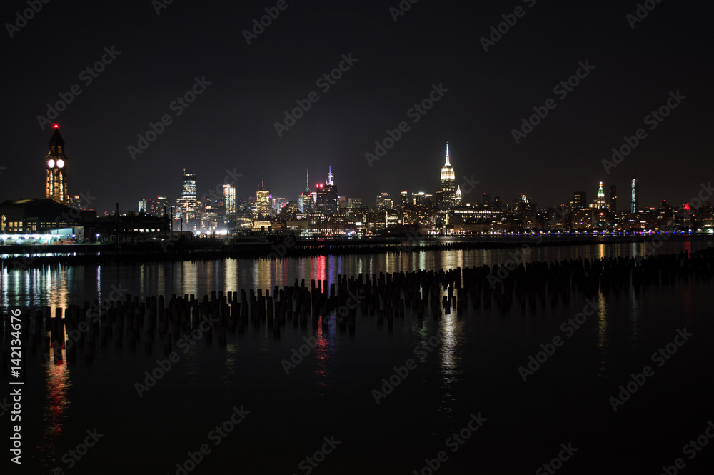 Midtown and Downtown Manhattan Lit Skyline Reflecting in the Hudson at Night as Seen from Newport Green Park in Jersey City, USA